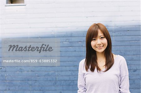 Japanese Women Standing Against Bricked Wall