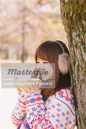 Japanese Women Leaning On Tree And Holding Cup Of Tea