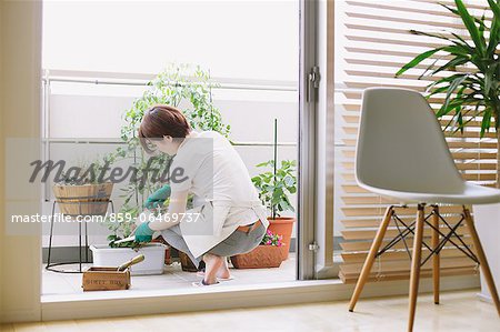 Mid adult woman gardening on the balcony