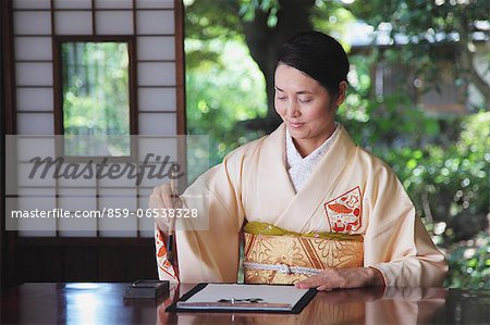Woman in a kimono practicing calligraphy