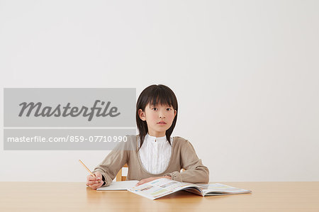 Young girl doing her homework on wooden desk