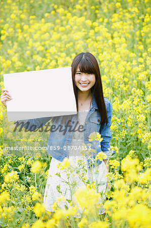 Attractive young Japanese woman in a rapeseed field