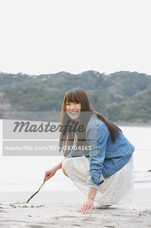 Attractive young Japanese woman by the sea