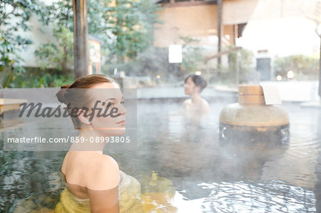 Caucasian woman with Japanese friend bathing at traditional hot spring, Tokyo, Japan