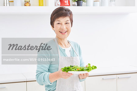 Japanese senior woman with salad in the kitchen