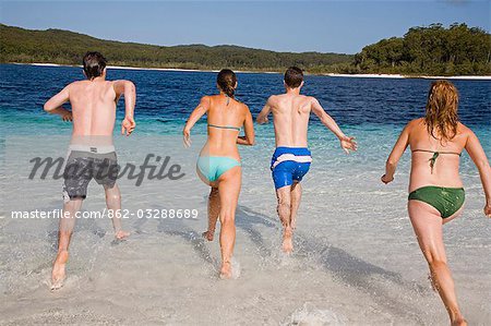 A group dive in to the clear waters of Lake McKenzie on Fraser Island. Ringed by a white sand beach,the lake is one of the many naturally formed lakes on the island.
