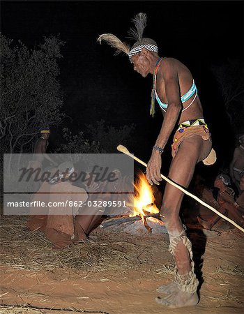 A bushman,or San,dances during a sing-song round their campfire. The men have rattles wound round their legs to help the rest of them keep rhythm during their dances.These NS hunter gatherers live in the Xai Xai Hills close to the Namibian border. Their traditional way of life is fast disappearing.