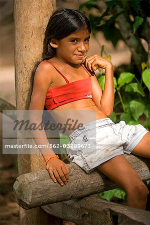 Young Girl Relaxing Agianst A Pole In The Village Of Maguari On The Banks Of The
