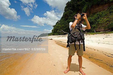 Brazilian Photographer Ion David photographing the rainforest on the banks of the Amazon River during the dry season,Amazon Region,Brazil. .