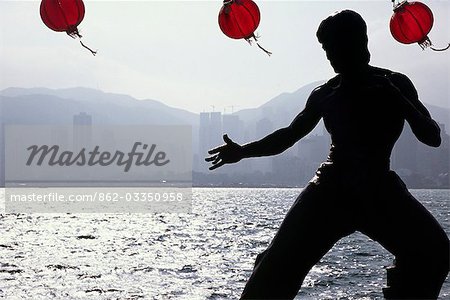 A statue of cult figure Bruce Lee is silhouetted on the Hong Kong waterfront. The Avenue of the Stars on the Tsim Sha Tsui East Promenade pays homage to the stars of the Hong Kong film industry.