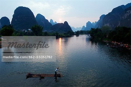 China,Guangxi Province,Yangshuo,near Guilin. Karst limestone mountain scenery and bamboo raft on the Li River