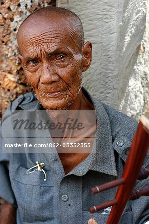 Cambodia,Siem Reap,Angkor. Old man selling souvenirs in front of the East Mebon temple.
