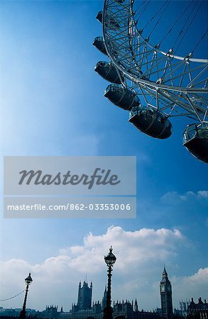 The London Eye,with Big Ben and the houses of Parliament in the background. The London Eye is the largest observation wheel ever built and has been open to the public since 2000.