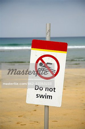 Do Not Swim sign warns holiday makers not to swim among the surfers on Fistral Beach,Newquay