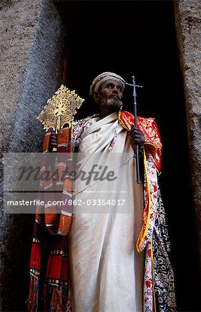 A priest holds a pair of the monastery's many ancient crosses.