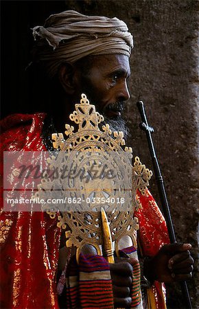 A priest holds a pair of the monastery's many ancient crosses.