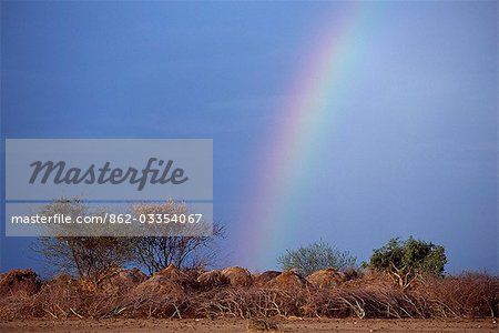 A rainbow rises behind the temporary grass huts of a Nyangatom settlement. The Nyangatom or Bume are a Nilotic tribe of semi-nomadic pastoralists who live along the banks of the Omo River in south-western Ethiopia.