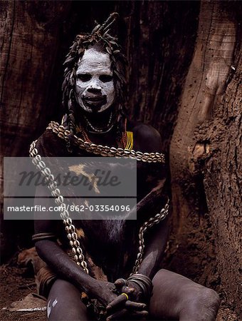 A Karo woman wears an elaborate headdress made from the wing-cases of beetles and a cape of calf skin fringed with cowrie shells. A small Omotic tribe related to the Hamar,who live along the banks of the Omo River in southwestern Ethiopia,the Karo are renowned for their elaborate body painting using white chalk,crushed rock and other natural pigments.