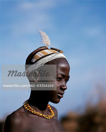 A young Dassanech boy with an elaborate clay hairdo and headband of beads at his village in the Omo Delta. Much the largest of the tribes in the Omo Valley numbering around 50,000,the Dassanech (also known as the Galeb,Changila or Merille) and Nilotic pastoralists and agriculturalists.