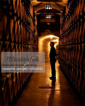 The foreman of works inspects barrels of Rioja wine in the underground cellars at Muga winery The foreman of works inspects barrels of Rioja wine in the underground cellars at Muga winery