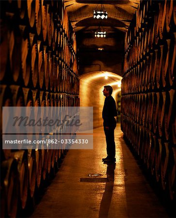 The foreman of works inspects barrels of Rioja wine in the underground cellars at Muga winery