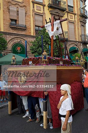 Spain,Andalucia,Seville. A young boy accompanies the procession of one of the Catholic brotherhoods through the streets of Seville.