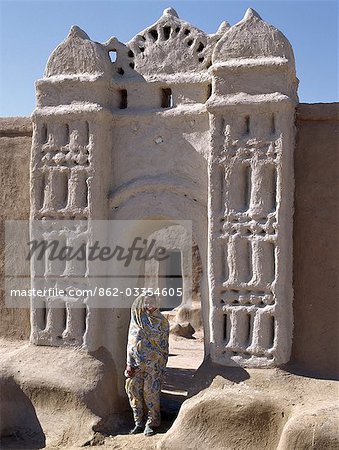 A Nubian girl stand in an archway at the village of Qubbat Selim. Traditional Nubian architecture. Traditional Nubian architecture and plasterwork of a fine archway to a house and its courtyard at Qubbat Selim.