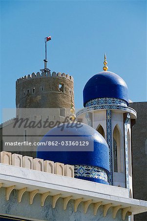 The ornate domes and minaret of the Khor Mosque contrast with the old walls of Fort Mirani