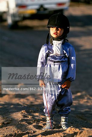 A jockey in racing silks at Al Shariq camel race track. Jockeys can be as young as 4 years old.