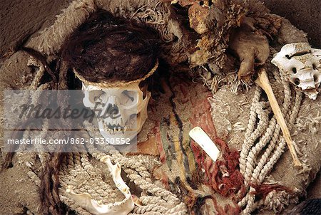 The skull of a Nazca mummy surrounded by pottery,bone and cloth fragments in the Cemetery of Chauchilla,southern Peru.