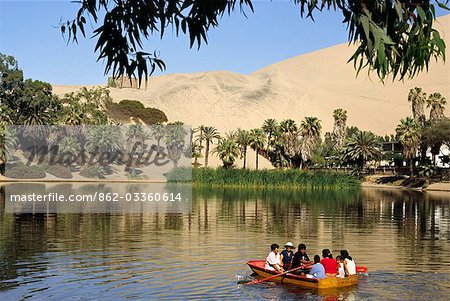 A family rows out onto the oasis lagoon of Huacachina. The waters of the desert oasis,near Ica in southern Peru,are heralded as having curative effects.