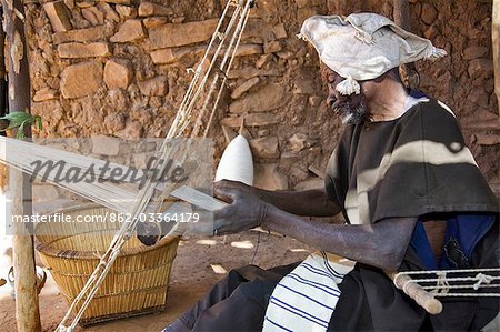 Mali,Dogon Country. An old man operates a narrow loom at Songho,an attractive Dogon village on top of the Bandiagara escarpment. Mali is Africa’s second largest producer of cotton.