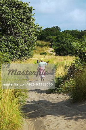 Mozambique,Inhaca Island. A Mozambique lady carries her hoe after working in the fields on Inhaca Island in Mozambique. Inhaca Island is the largest island in the Gulf of Maputo,and lies 24km from the mainland.