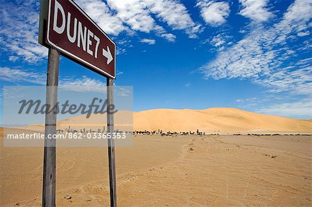 Namibia,Skeleton Coast,Walvis Bay. The sign to the popular tourist dune of Dune 7 located near to Walvis Bay and Swakopmund. Dune 7 is a large sand dune in the Namib Desert,one of the largest in the world and the highest in the coastal belt popular with sandboarders.