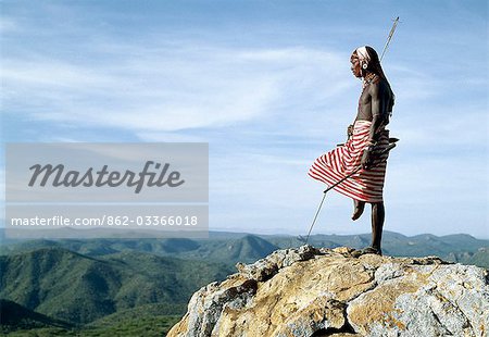 A Samburu warrior stands sentinel over a vast tract of unspoilt,semi-arid bush scrub country. The poor pasture here is an important resource for the pastoral Samburu people.