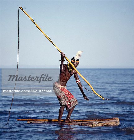 The Turkana spear-fish in the shallow waters of Lake Turkana. The wooden  shaft has a