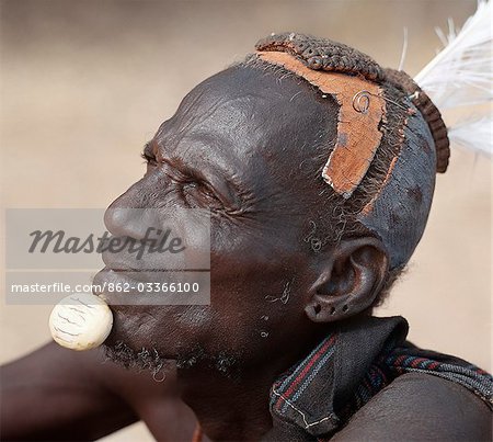 Turkana elders wear decorative ivory lip ornaments,secured in position by a spigot which is inserted in a hole pierced below the man's lower lip after initiation. This singular form of decoration was once widespread but is rarely seen today. Likewise,the traditional clay hairdo is gradually dying out.