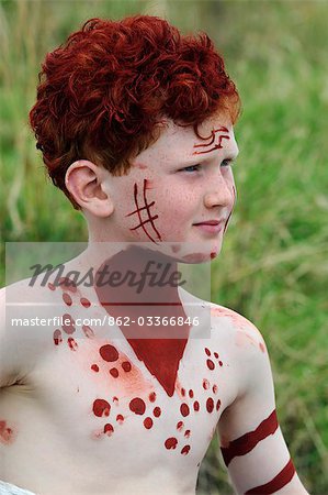 Kenya,Masai Mara National Reserve. A young boy on a family holiday dressed up and painted with ochre in the style of a Maasai warrior .