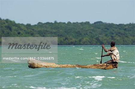 Kenya,Kilifi. A local fisherman paddles his dugout canoe across Kilifi Creek.