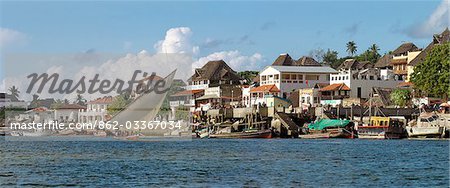 Kenya,Lamu. A dhow sails along the waterfront of Lamu Town.