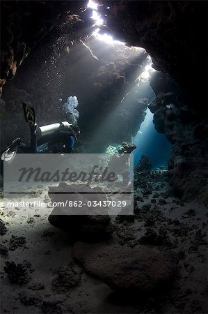 Egypt,Red Sea. A Diver explores the caves at St. John's Reef in the Egyptian Red Sea