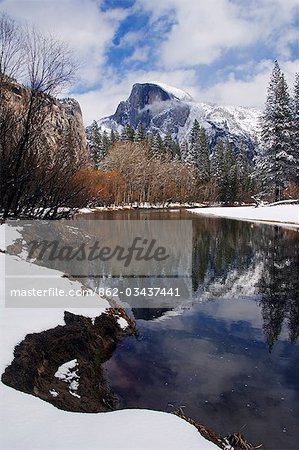 USA,California,Yosemite National Park. A reflection of Half Dome peak in the Merced River after fresh snow fall in Yosemite Valley.