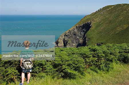 UK,Wales,Pembrokeshire. A young boy looks out from Dinas Head on a walk along the Pembrokeshire Coastal Path .