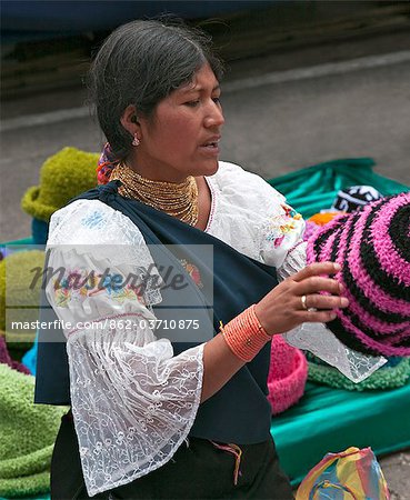 Ecuador, An indigenous Ecuadorian woman selling woollen hats at Otavalo market.