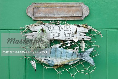 Fish Tales Told Here sign on the cottage door, Clovelly, Devon, UK Fish Tales Told Here sign on the cottage door, Clovelly, Devon, UK