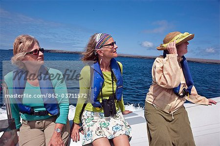 Galapagos Islands, Visitors to Genovese Island return to their motor yacht on a  panga  or inflatable rubber dingy.