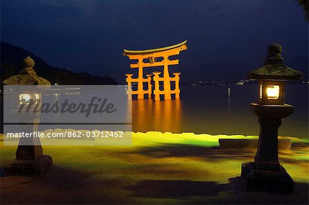 Lanterns infront of red torii gate of Itsukushima jinja shrine