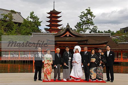 Japan,Honshu Island,Hiroshima Prefecture,Miyajima Island,Itsukushima Shrine. Wedding ceremony family portrait in front of a 15th Century pagoda.