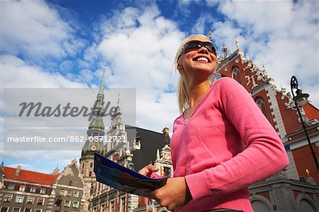 Woman standing outside House of Blackheads in Town Hall Square (Ratslaukums), Riga, Latvi.