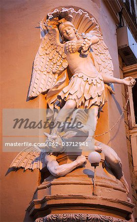 Europe, Malta, Valletta; St.Michael defeating the devil sculpture on a street corner